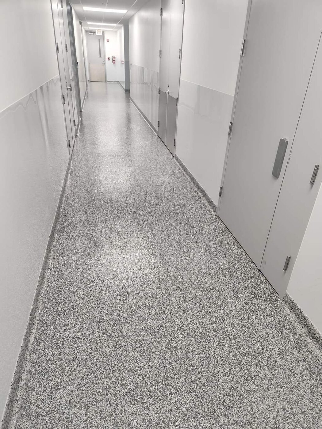 Gray flake epoxy flooring in a commercial hallway