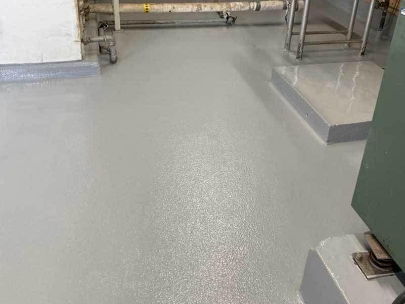 Seamless gray industrial epoxy floor around equipment