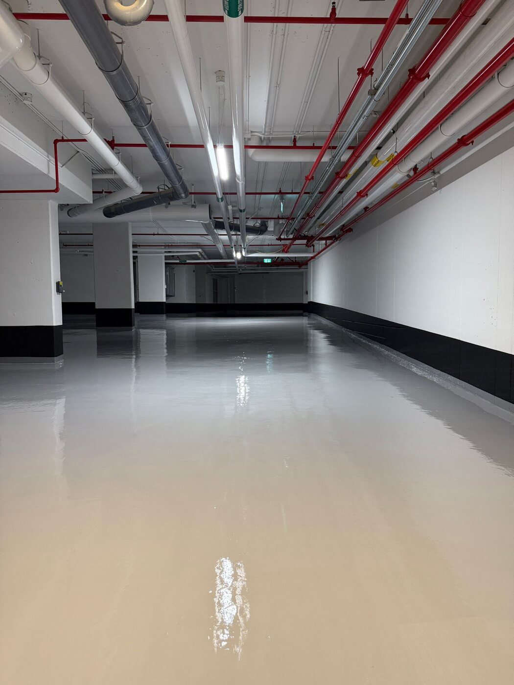 Light-coloured seamless epoxy floor in a service area
