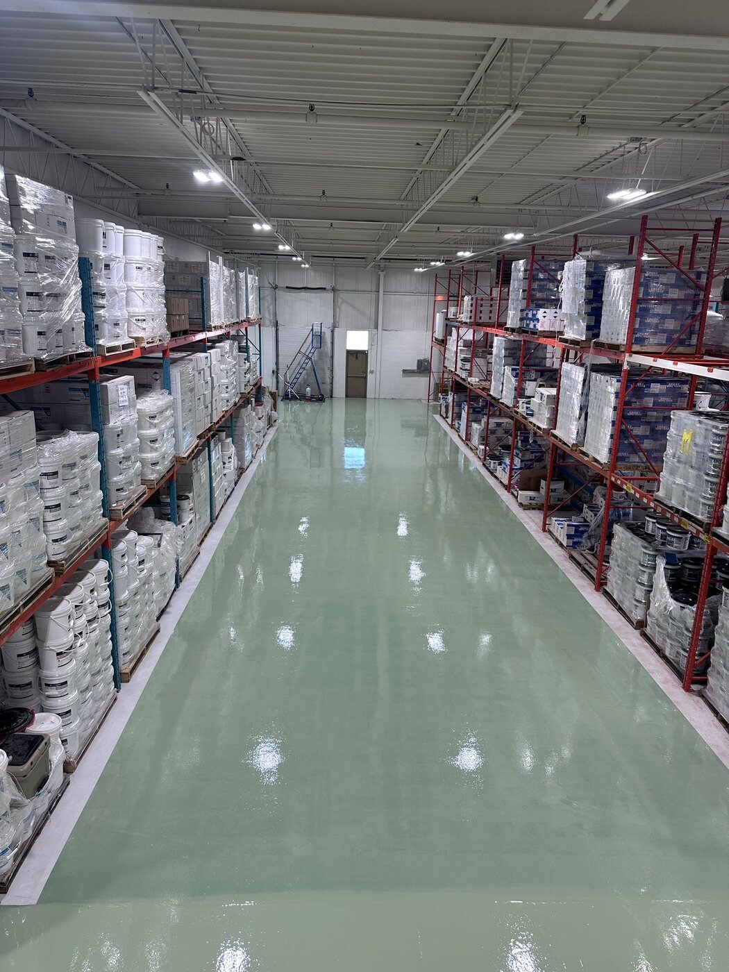 Glossy epoxy floor between warehouse storage racks