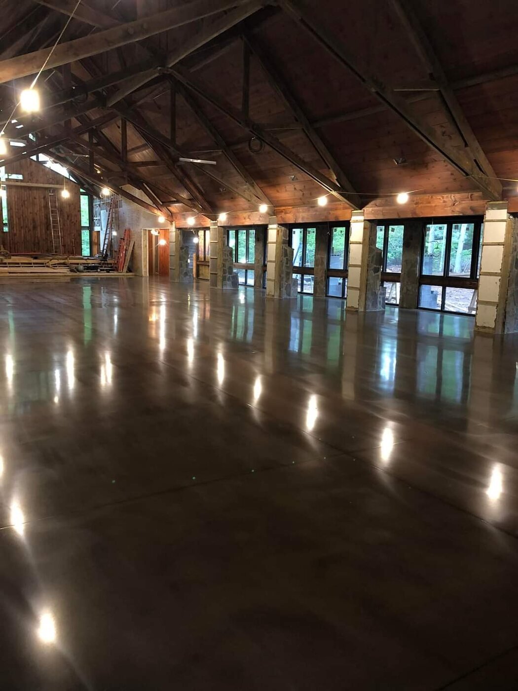 Dark polished concrete floor in a large timber hall