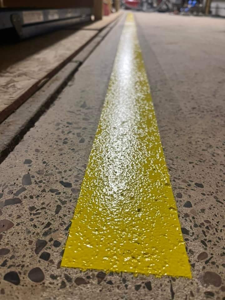 Polished industrial concrete with a yellow safety line